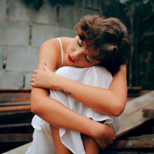 Depressed Woman Hugging Herself and Practicing Self-Love
